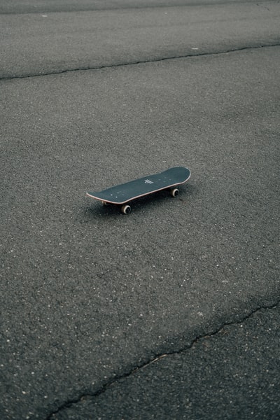 灰色混凝土地板上的黑色滑板